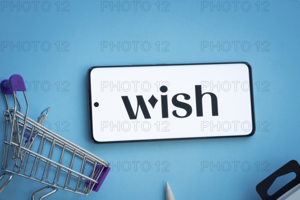 Dhaka, Bangladesh- 03 July 2025: Smartphone displaying Wish logo with shopping cart on a blue background