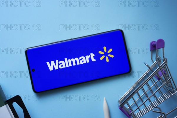 Dhaka, Bangladesh- 03 July 2025: Smartphone displaying Walmart logo with shopping cart on a blue background