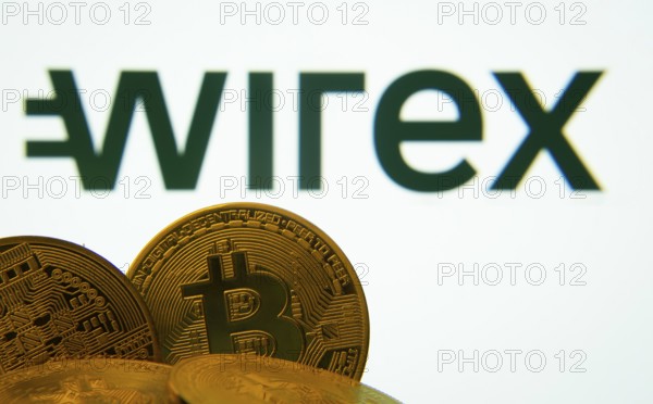 Dhaka, Bangladesh- 27 July 2025: Close-up of Bitcoin coins with the wirex logo visible on a screen in the background