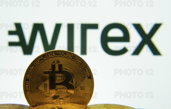 Dhaka, Bangladesh- 04 April 2025: Close-up of Bitcoin coins with the wirex logo visible on a screen in the background