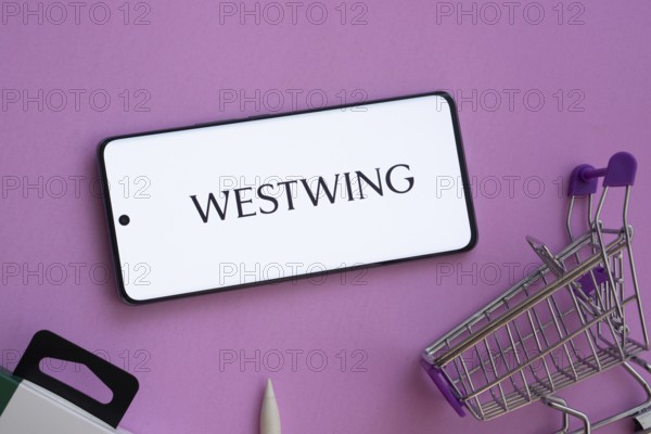 Dhaka, Bangladesh- 03 July 2025: Smartphone displaying Westwing logo alongside a shopping cart on a purple background