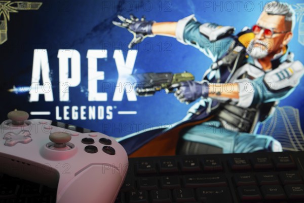 Dhaka, Bangladesh- 19 Sep 2025: A close-up of a white gamepad with the Apex Legends seen on screen in the background