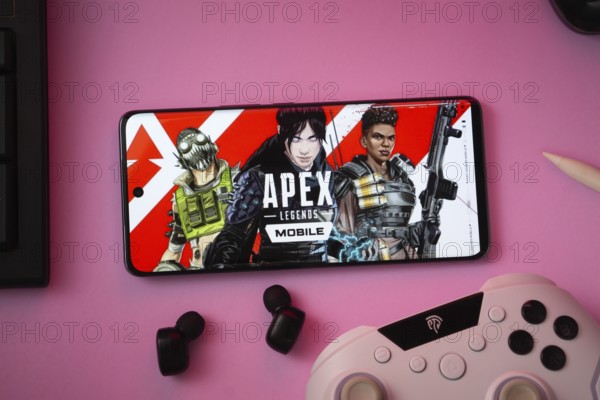 Dhaka, Bangladesh- 19 Sep 2025: A close-up of a white gamepad with the Apex Legends mobile seen on screen in the background