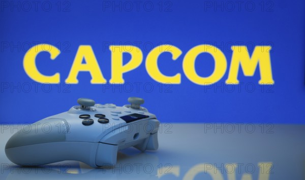 Dhaka, Bangladesh- 19 Sep 2025: A close-up of a white gamepad with the Capcom seen on screen in the background