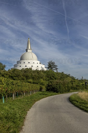 White pagoda surrounded by green nature and meadows under a blue sky, Stupa am Wagram Grafenwörth Weinviertel Lower Austria Austria