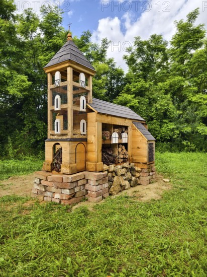 Miniature church made of wood Insect hotel surrounded by green landscape under a cloudy sky, Weinviertel Lower Austria Austria