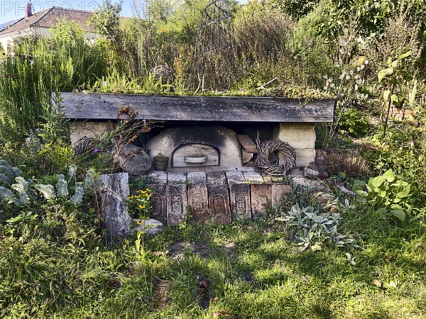 An old stone oven embedded in nature with surrounding plants and a rustic atmosphere, Weinviertel Lower Austria Austria