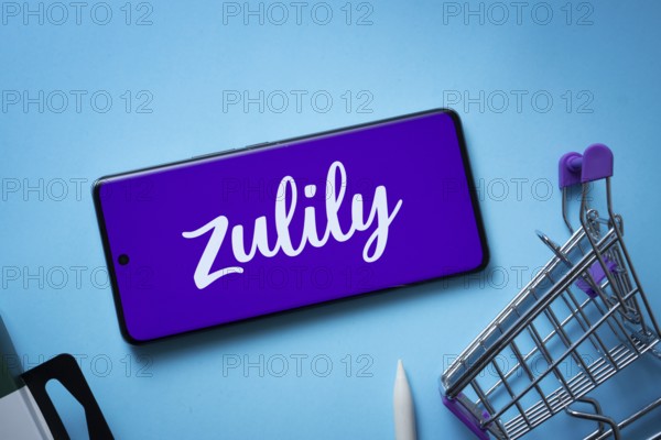 Dhaka, Bangladesh- 03 July 2025: Smartphone displaying Zulily logo with shopping cart on a blue background