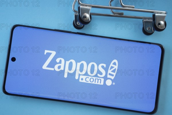 Dhaka, Bangladesh- 03 July 2025: Smartphone screen showing the Zappos logo with shopping cart wheels on a blue background