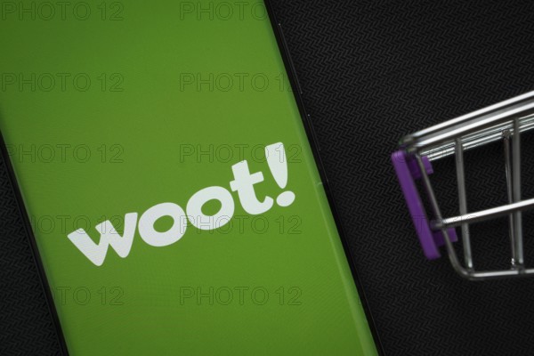 Dhaka, Bangladesh- 03 July 2025: A smartphone displaying the Woot logo next to a miniature shopping cart on a background