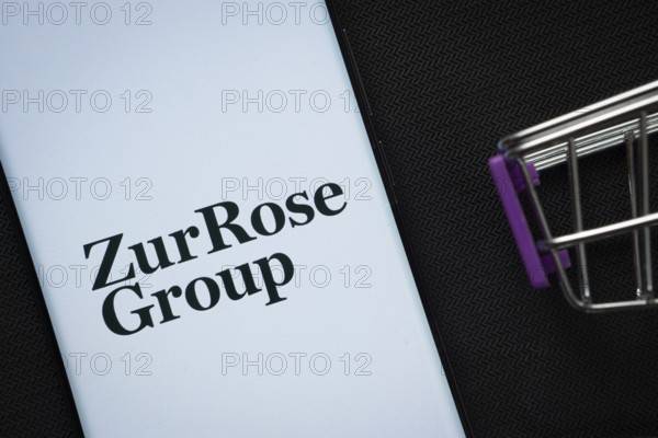 Dhaka, Bangladesh- 03 July 2025: A smartphone displaying the Zur Rose Group logo next to a miniature shopping cart on a background