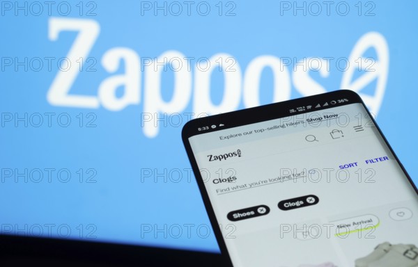 Dhaka, Bangladesh- 03 July 2025: Smartphone displaying Zappos web interface against Zappos logo background