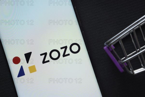 Dhaka, Bangladesh- 03 July 2025: A smartphone displaying the ZOZO logo next to a miniature shopping cart on a background