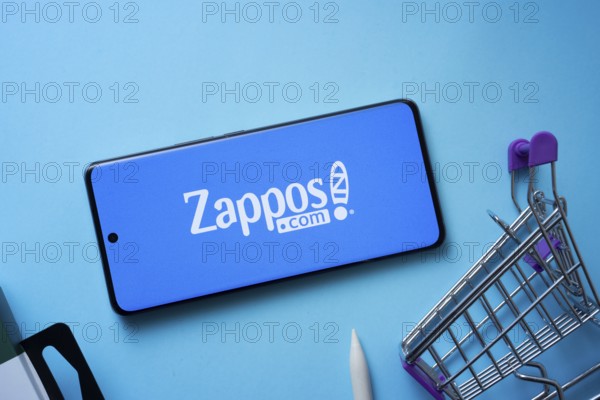 Dhaka, Bangladesh- 03 July 2025: Smartphone displaying Zappos logo with shopping cart on a blue background