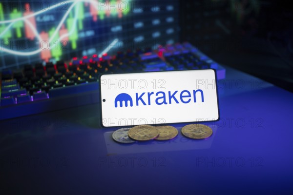 Bright Kraken logo on a phone with a vibrant trading screen and coins in view