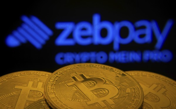 Dhaka, Bangladesh- 03 Sep 2025: Close-up of Bitcoin coins with the zebpay logo visible on a screen in the background