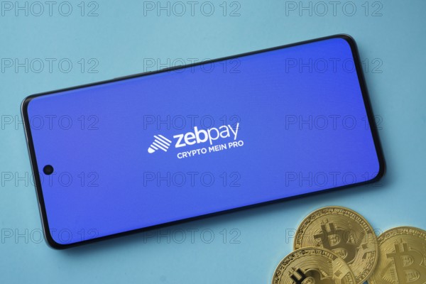 Dhaka, Bangladesh- 03 Sep 2025: zebpay logo on smartphone screen near Bitcoin coin and QR code on blue background