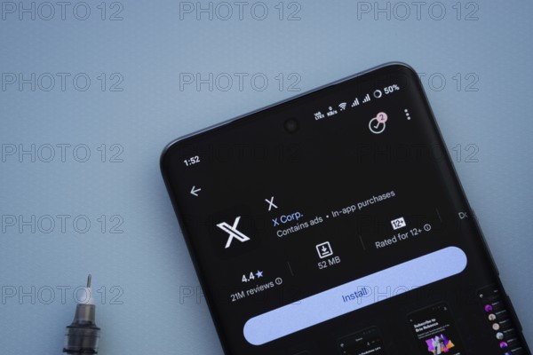 Dhaka, Bangladesh- 29 May 2025: On a blue surface, a smartphone displays the X app within the Google Play Store