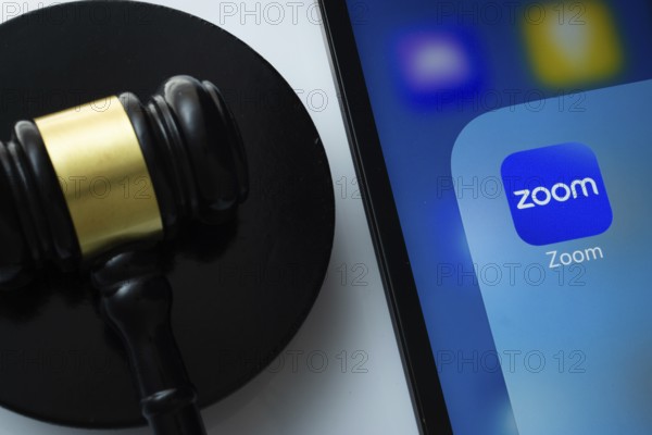 Dhaka, Bangladesh- 18 March 2025: A close up of an iPad screen displaying the zoom app alongside a judge's gavel