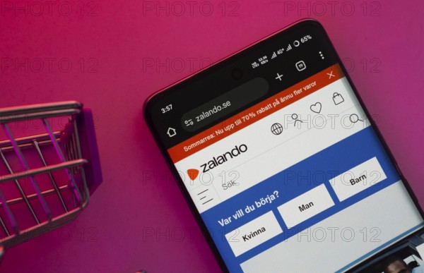Dhaka, Bangladesh- 23 June 2025: A smartphone displaying the Zalando website with a shopping cart is shown on a vibrant background