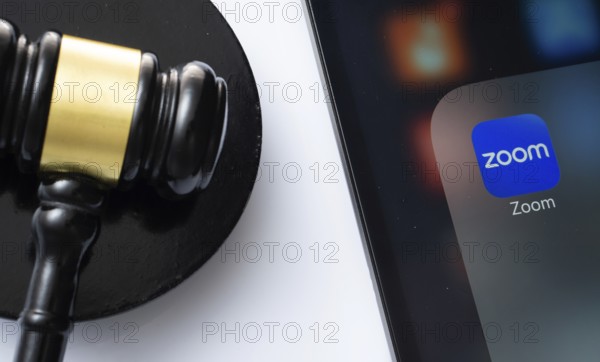 Dhaka, Bangladesh- 18 March 2025: A close up of an iPad screen displaying the zoom app alongside a judge's gavel