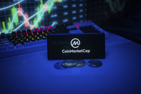 A phone showing CoinMarketCap with lying coins, highlighting cryptocurrency market information