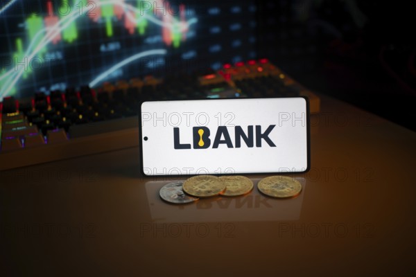 Phone displays LBank logo with crypto coins and trading screen in background