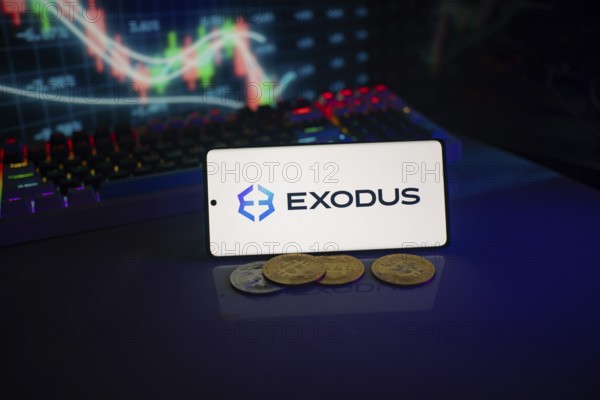 Exodus logo on a smartphone amid digital currencies and trading market charts