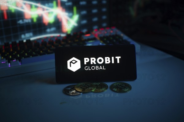Probit Global logo with coins on a desk, against trading graphs backdrop