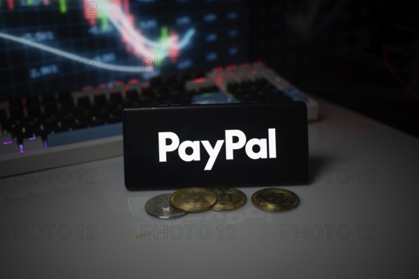 PayPal logo shown with coins and illuminated market analysis graph