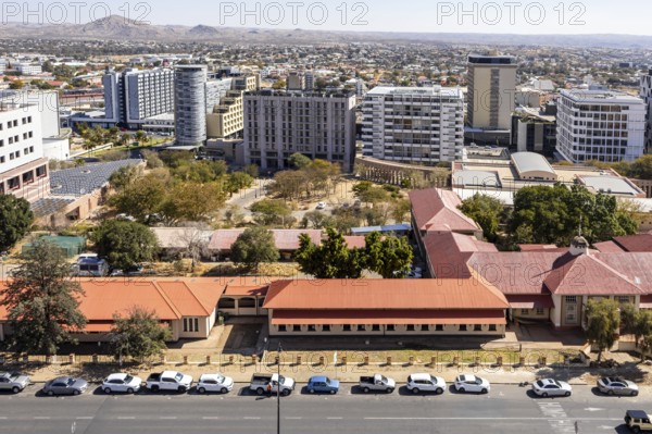 Modern downtown Windhoek, Namibia, with tall contemporary buildings, wide streets, moving cars, and a clear blue sky