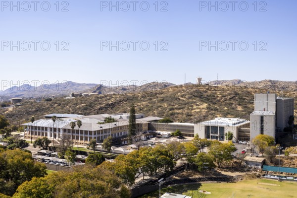 Modern downtown Windhoek, Namibia, with tall contemporary buildings, wide streets, moving cars, and a clear blue sky