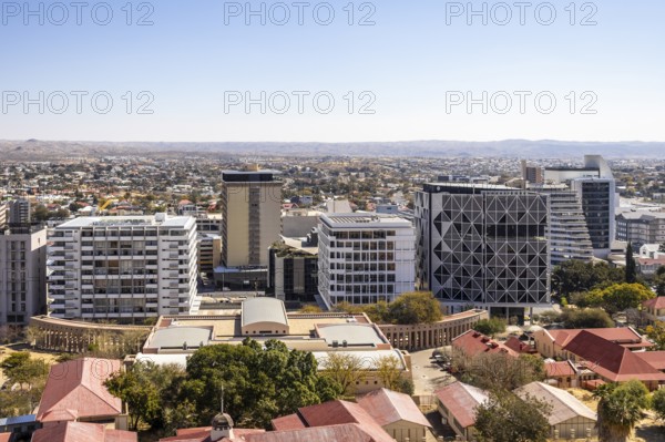 Modern downtown Windhoek, Namibia, with tall contemporary buildings, wide streets, moving cars, and a clear blue sky