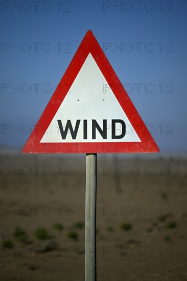 Caution wind sign on a road near Oranjemund, diamond restricted area, Karas region, Namibia