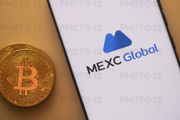 Bitcoin coin with a smartphone displaying the MEXC Global logo on a light background