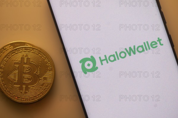 Smartphone displaying HaloWallet logo beside a physical Bitcoin on an orange background