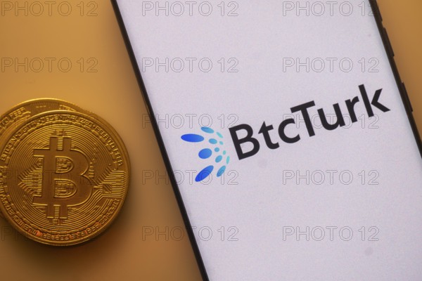 Bitcoin beside a smartphone with BtcTurk logo on a white background