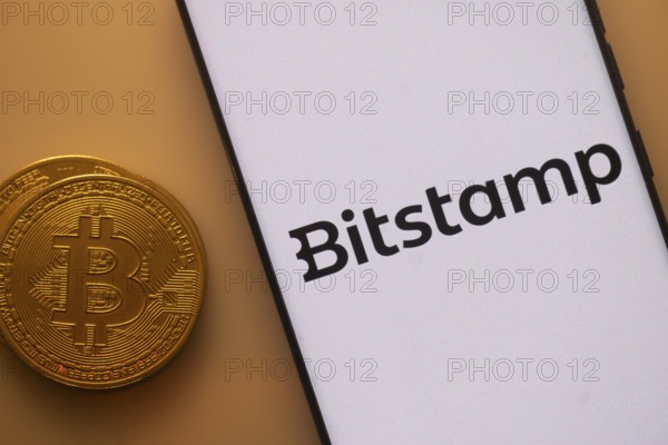 Bitstamp logo on white screen beside Bitcoin, indicating crypto trading platform
