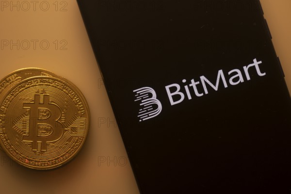 Bitcoin beside a smartphone with the BitMart logo on an orange backdrop