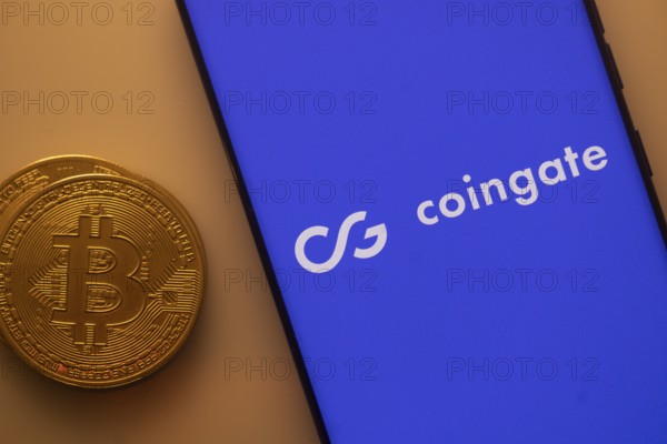 Bitcoin and Coingate logo on a blue smartphone screen set against orange