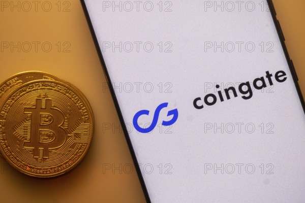 Bitcoin and Coingate logo on a smartphone against an orange background