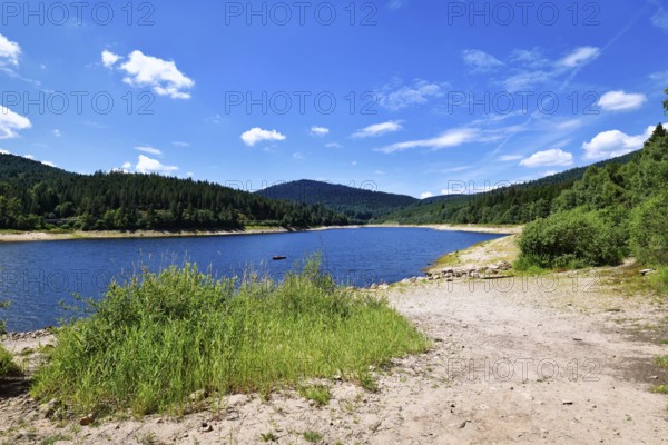 Beautiful mountain lake in the Black Forest in Forbach in Germany called Schwarzenbach Reservoir surrounded by forested hills under a clear sky
