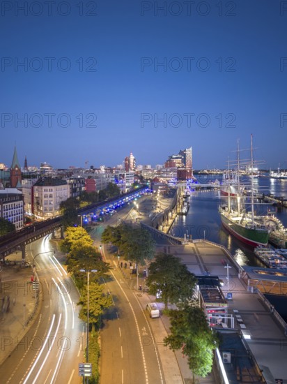 Evening atmosphere at the Landungsbrücken with a view of the Elbphilharmonie, the Rickmers Rickmers sailing ship and traces of lights from moving cars at the blue hour, Hamburg, Germany