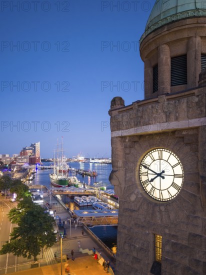Evening atmosphere at the Landungsbrücken with a view of the Elbphilharmonie and the historic sailing ship Rickmers Rickmers as well as the clock tower in the harbour at the blue hour, Hamburg, Germany