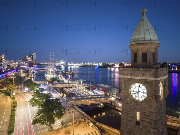 Evening atmosphere at the Landungsbrücken with a view of the Elbphilharmonie and the historic sailing ship Rickmers Rickmers as well as the clock tower in the harbour at the blue hour, Hamburg, Germany