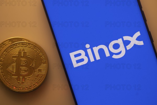 BingX app visible on a smartphone with Bitcoin coin beside it