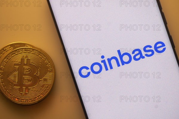 Coinbase app displayed on a smartphone beside a Bitcoin coin image