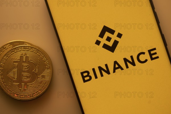Bitcoin coin next to Binance logo on a yellow background, associated with crypto market