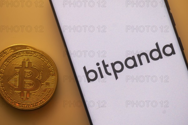 Bitcoin coin next to Bitpanda logo on a white background, involving digital investments