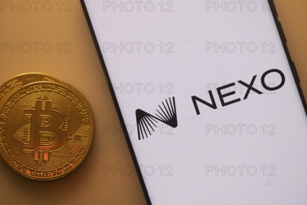 Nexo logo on smartphone screen beside Bitcoin, highlighting financial technology and cryptocurrency lending